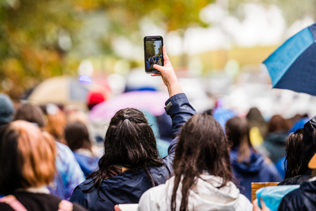 A student takes a photo of the march with their phone