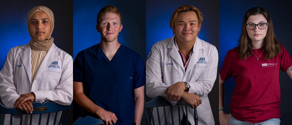 Portraits of two graduate and two undergraduate U N E students standing in front of a blue wall