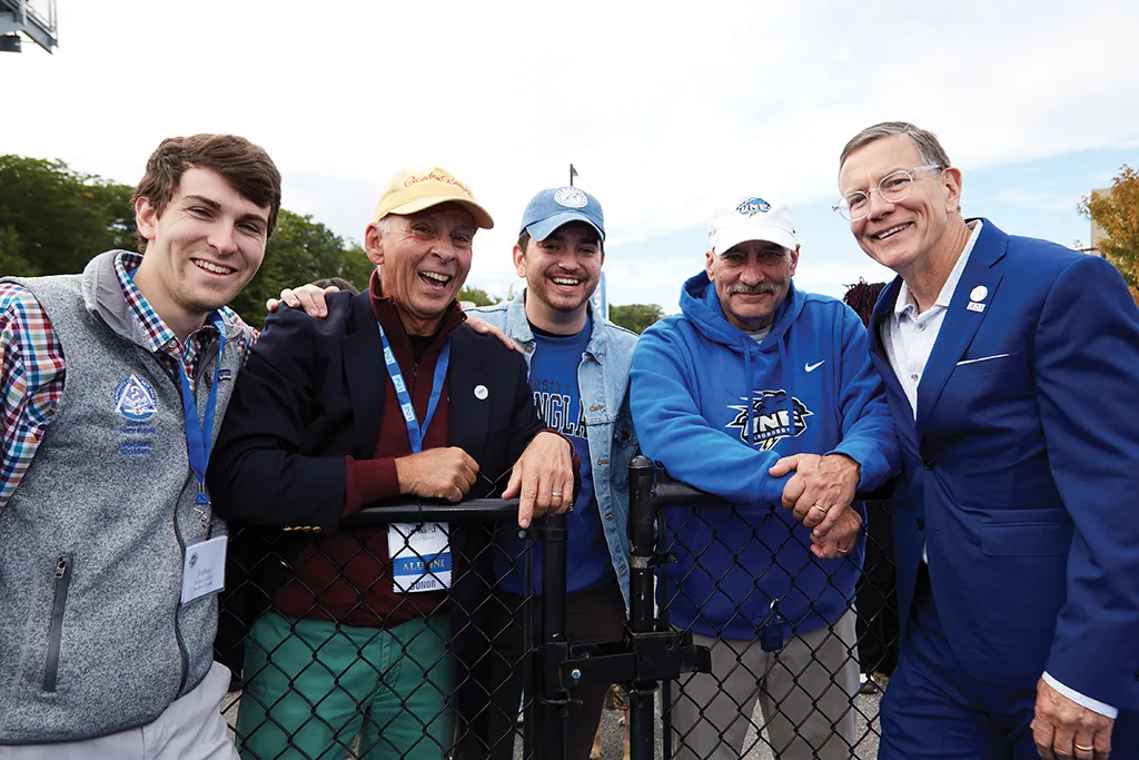 President Herbert stands with a U N E COM student and St. Francis alumni