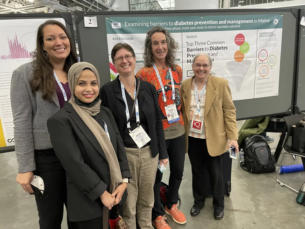 UNE researchers pose in front of a poster they presented at the American Public Health Association’s 150th Anniversary Annual Meeting