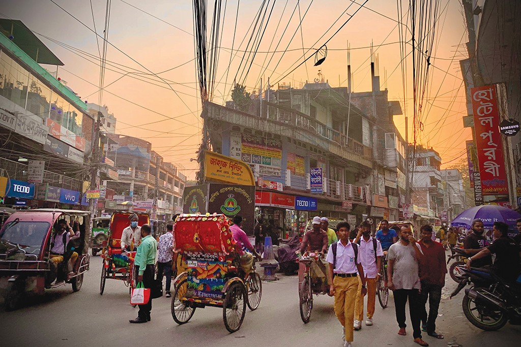 A downtown street in Tangail with people walking and buildings in the background