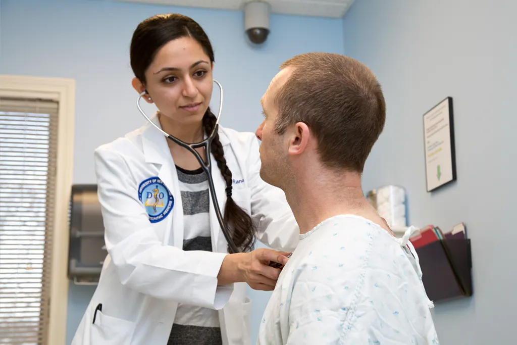 A U N E osteopathic medicine student examine a patient