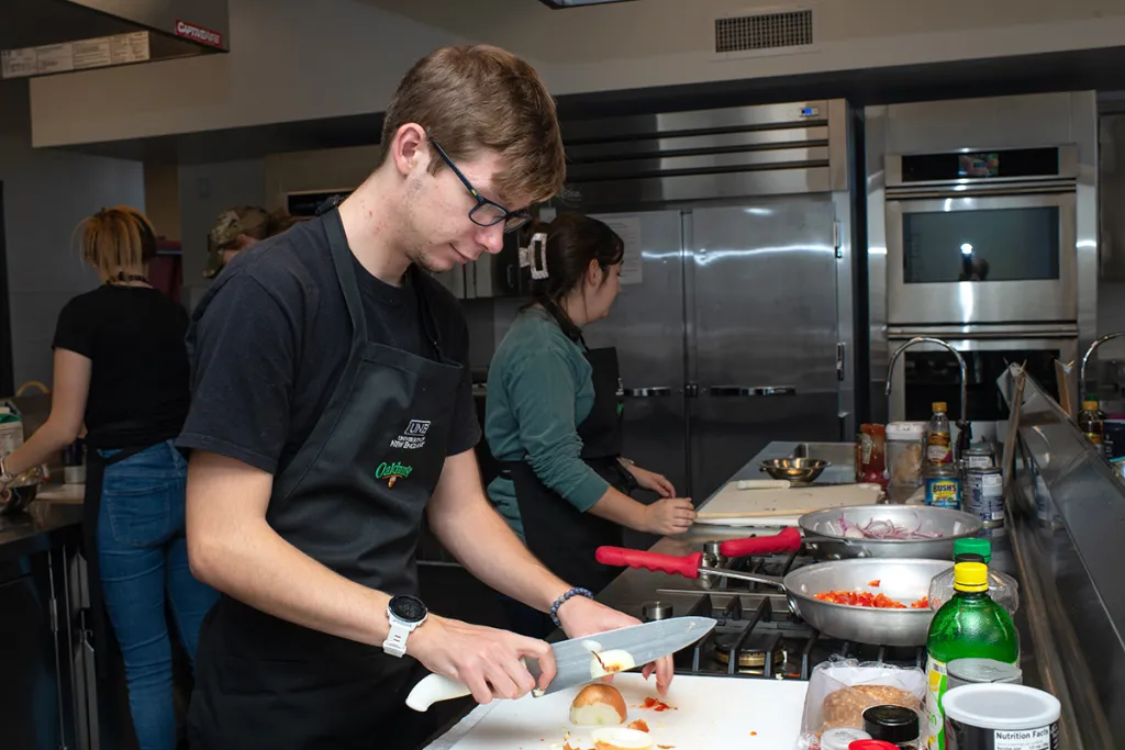 A nutrition student cutting an onion