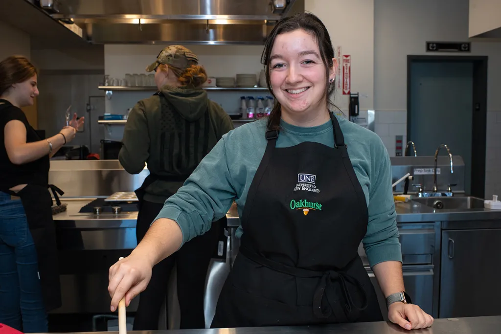 A nutrition smiles while they stir batter