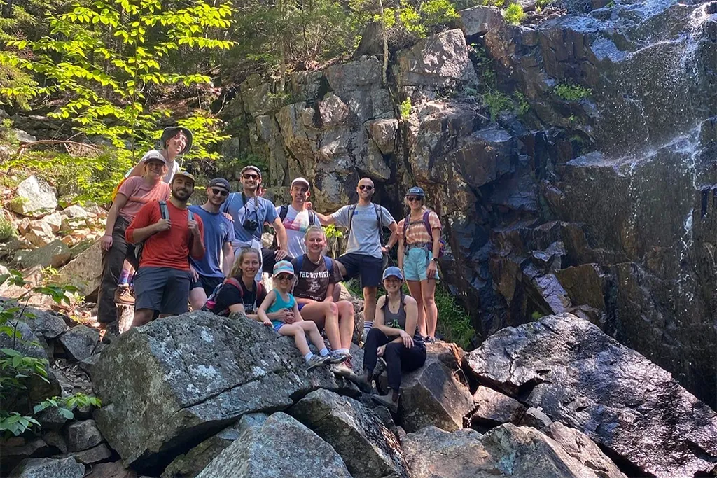 A group of U N E students standing on rocks during a hiking trip