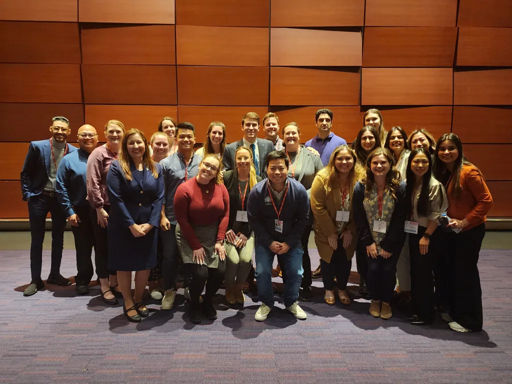 Debate participants pose for a group photo on stage