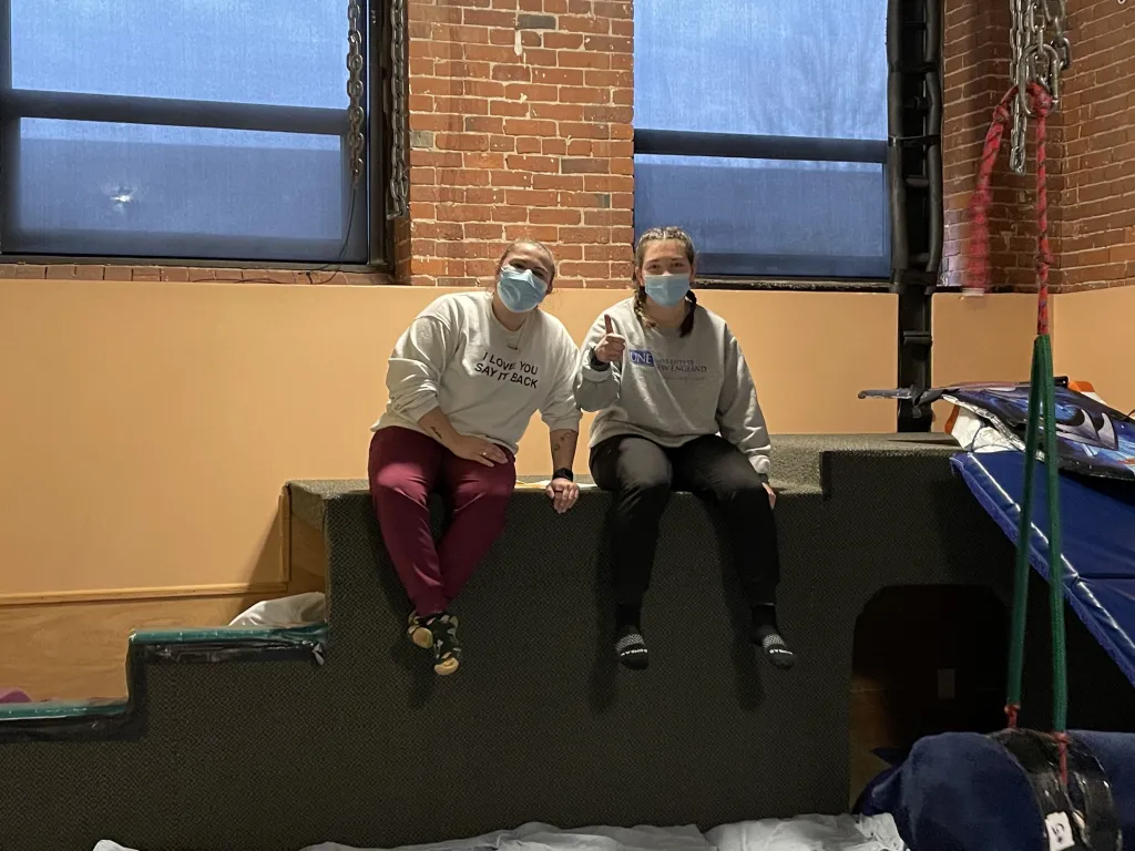 Two students in UNE sweatshirts pose at the OTA-Koomar Center