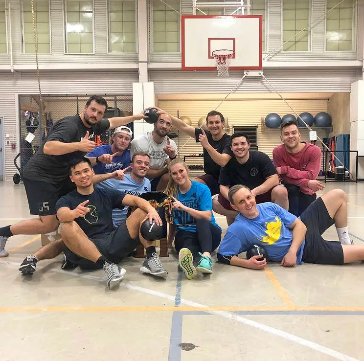A group of students posing in front of a basketball hoop in the Finley Recreation Center