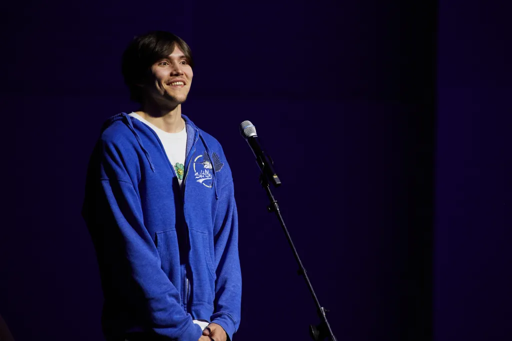 A male student stands at a microphone to ask a question
