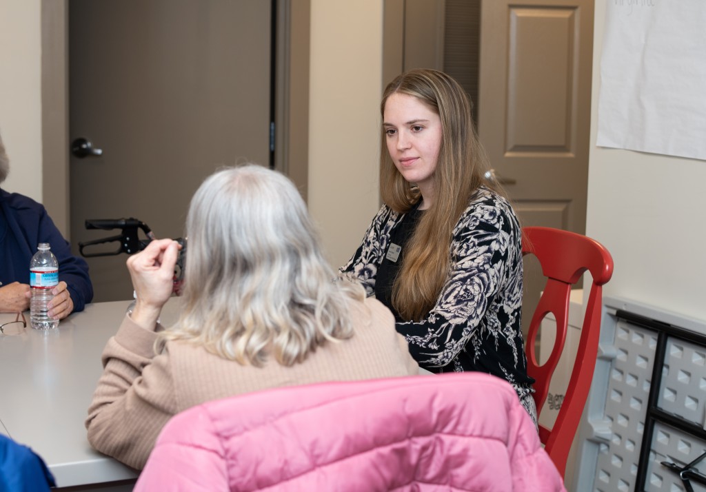 A student speaks with a resident of an assisted living facility