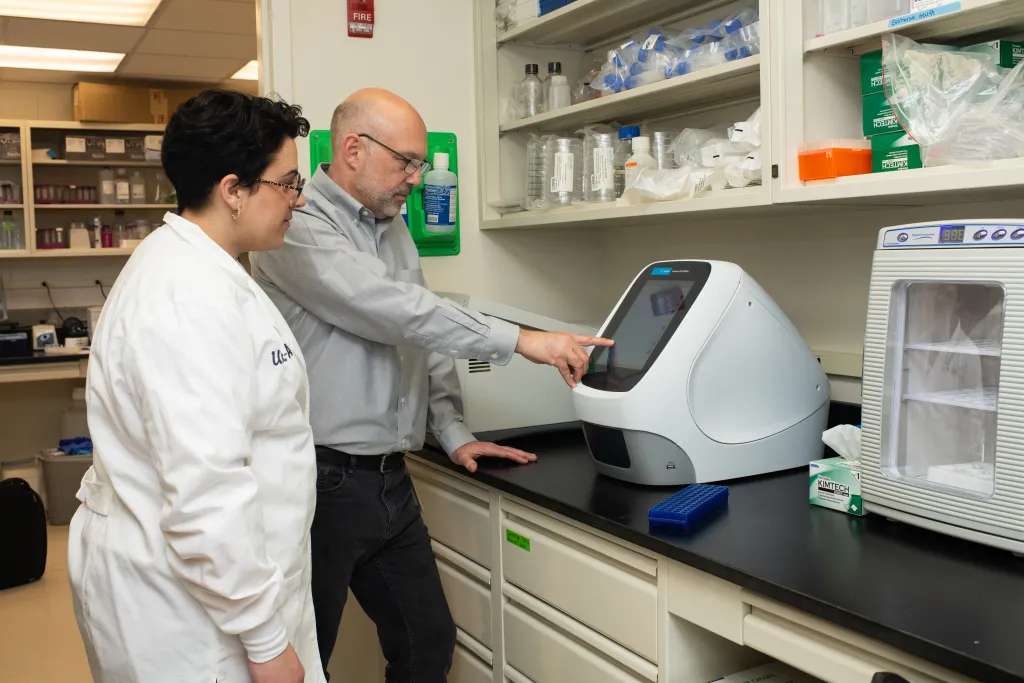 U N E faculty member Derek Molliver, Ph.D., does research in his lab with a U N E student