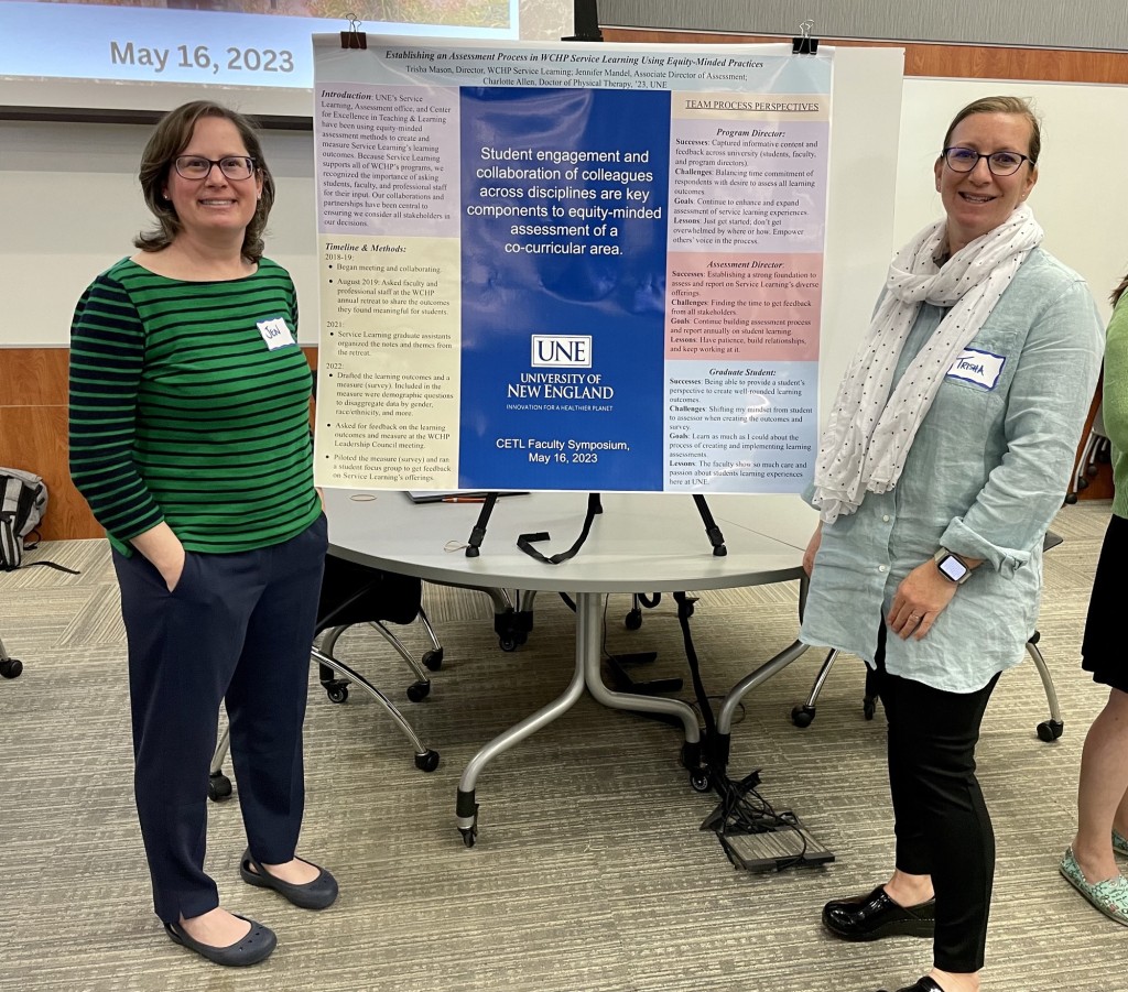 Jennifer Mandel and Trisha Mason stand next to their research poster