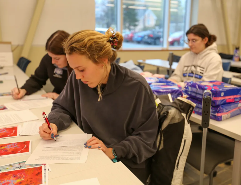students in a classroom writing notes in cards
