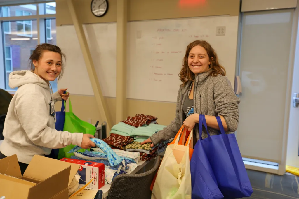 students putting reproductive health materials in bags
