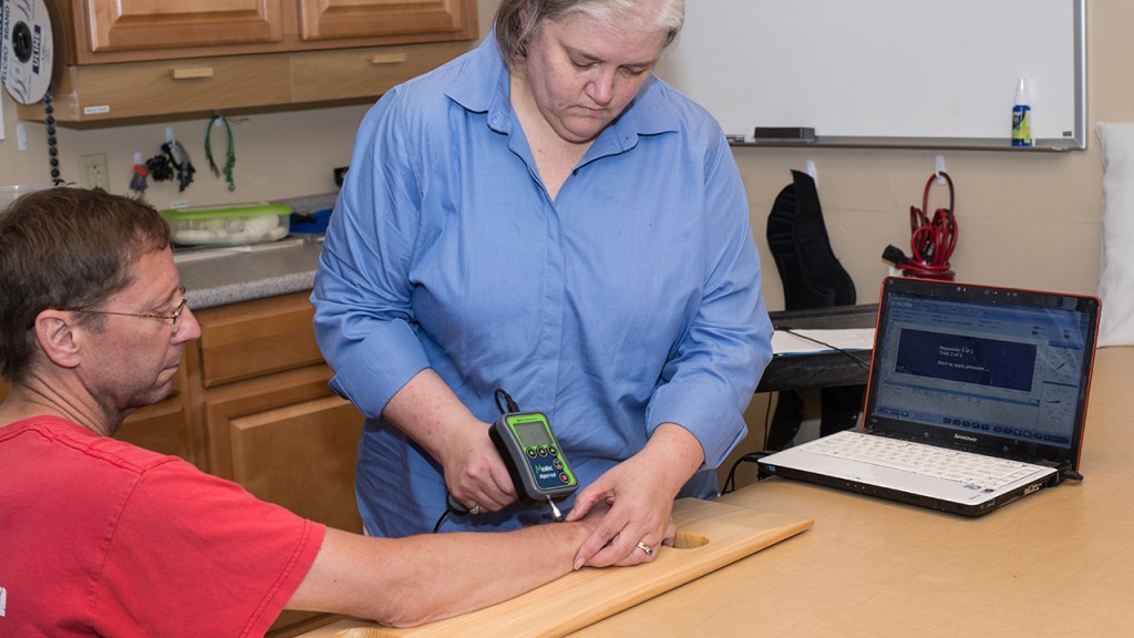 Katherine Rudolph uses a MedDoc AlgoMed on a patient to get pressure pain data
