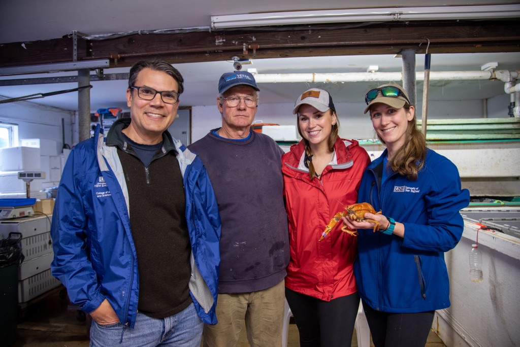 UNE's Charles Tilburg and Lindsay Forrette pose with the lobster and Capt. Gregg and Mandy Cyr