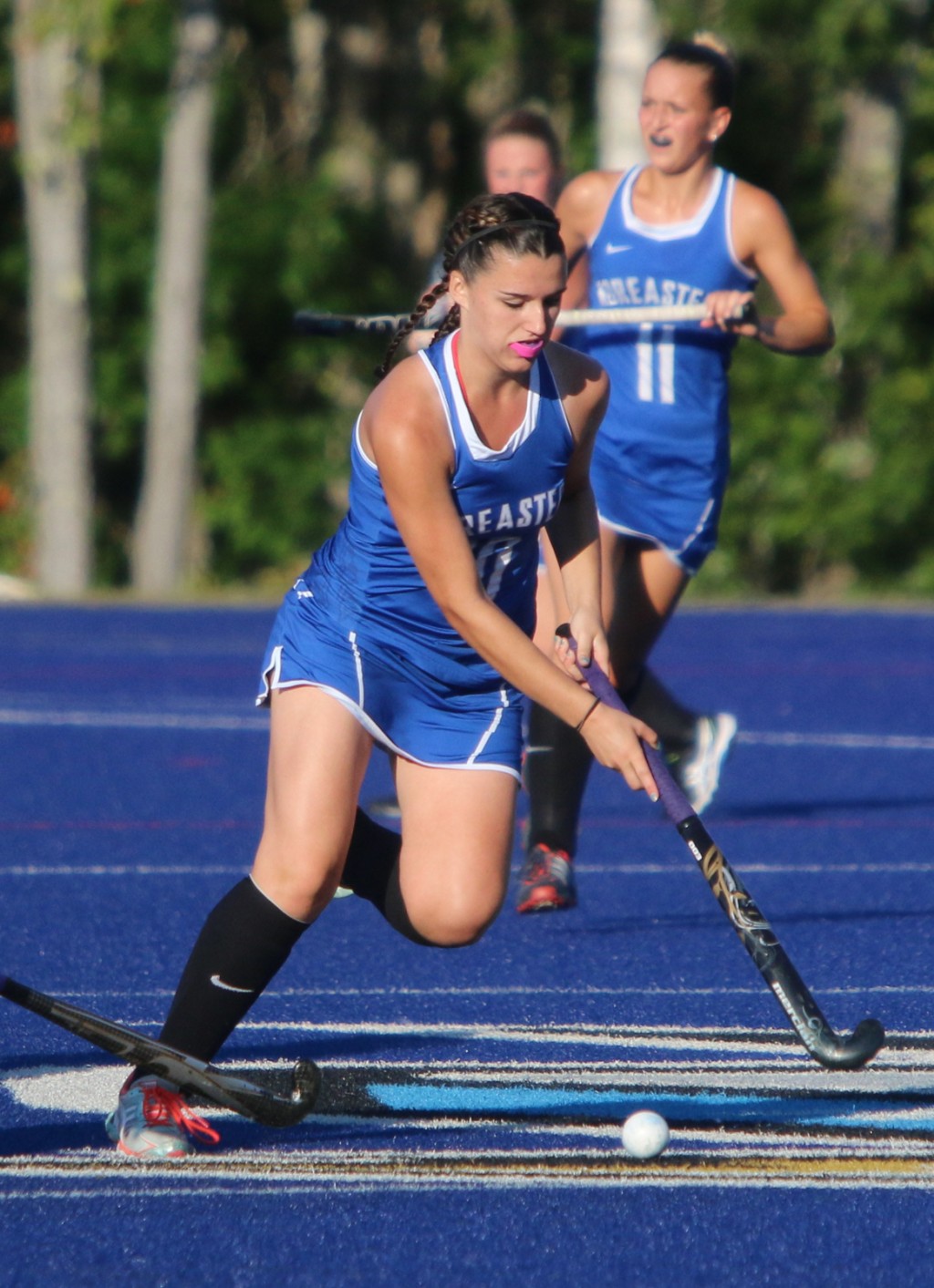 A player controls the ball during a women's field hockey game