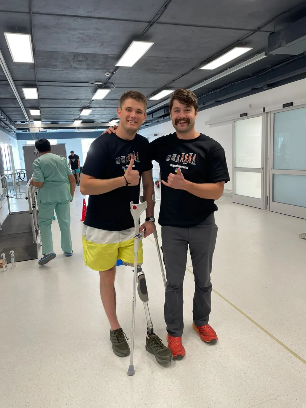 Motley poses with a soldier fitted with a prosthetic leg