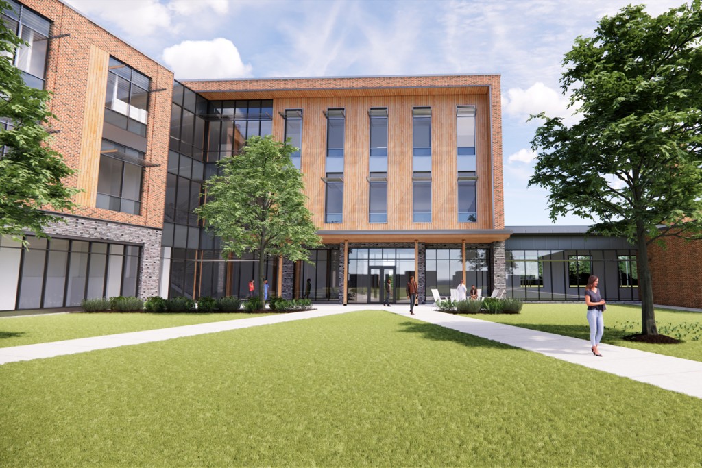 A rendering of the exterior of the upcoming C O M building showing a brick building and grass quad