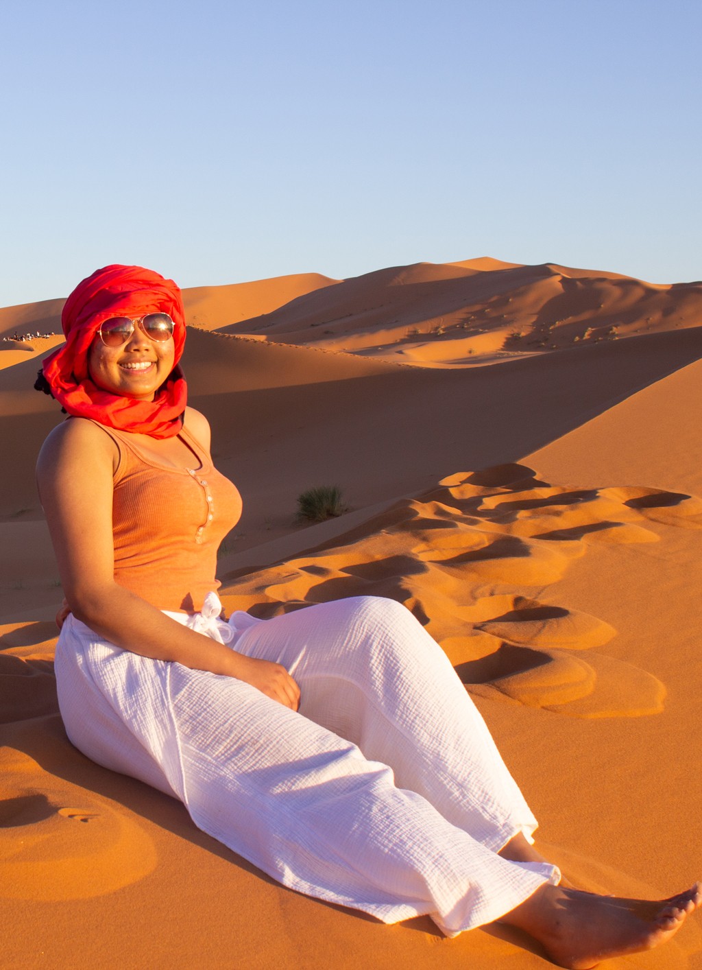 A student sitting on the sand of a Moroccan desert