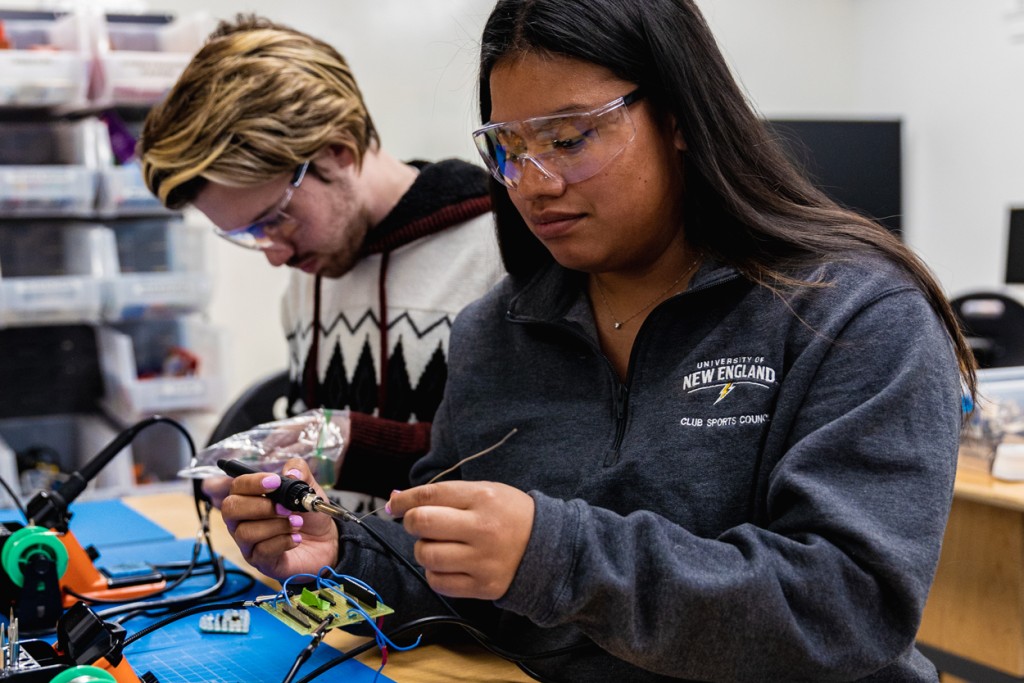 Two students soldering in the Makerspace