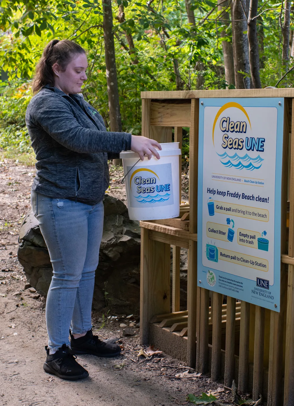 A student brings a bucket to the Clean the Seas drop-off location