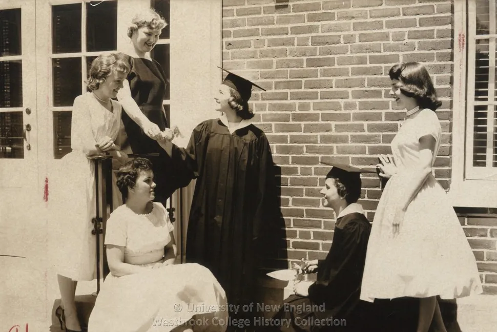 Historical black and white photo of a graduating student in their cap and gown