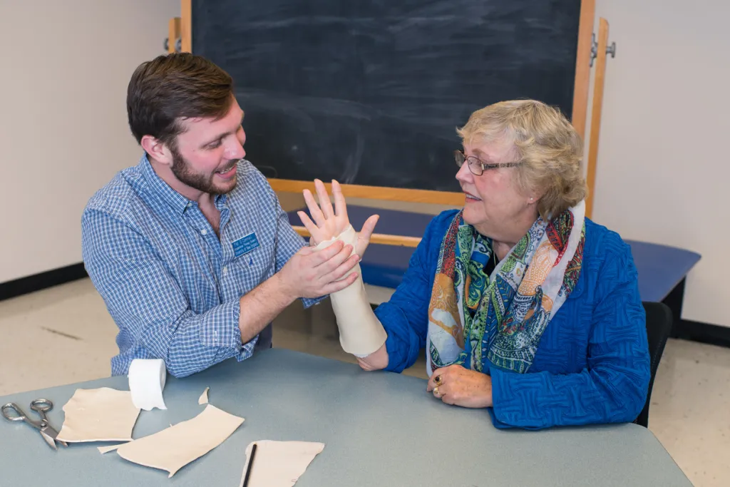 An occupational therapy student wraps the wrist of a patient