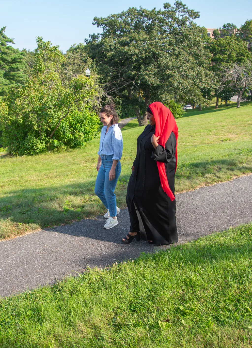 U N E Pharm.d. student Deqoo Mahamud walks with a university professional staff member