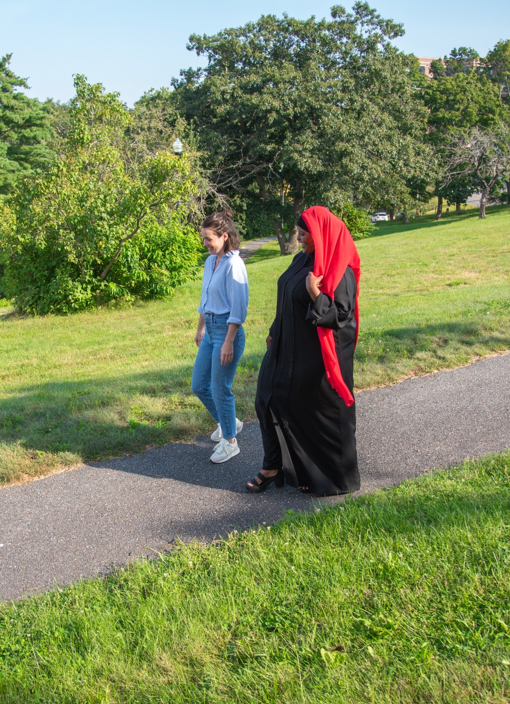 U N E Pharm.d. student Deqoo Mahamud walks with a university professional staff member