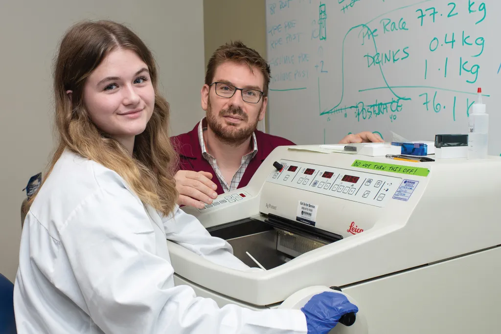 Jayden and Dr. Harrison working with lab equipment