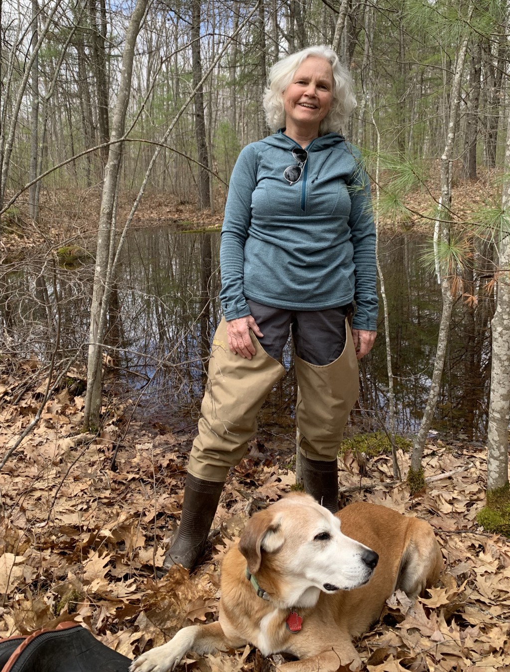 Pam Morgan stands with dog in woods