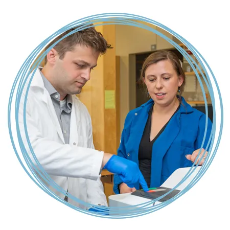 A student works alongside Dr. Balog in her lab
