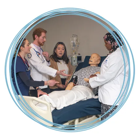 A group of health students from C O M, nursing, and pharmacy discuss treatment for a patient simulator in the Sim Lab