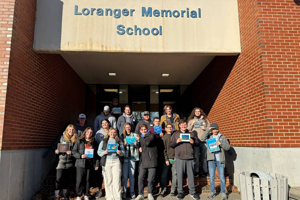 A group of students from UNE's Office of Citizenship and Civic Engagement pose in front of Loranger Memorial School in Old Orchard Beach