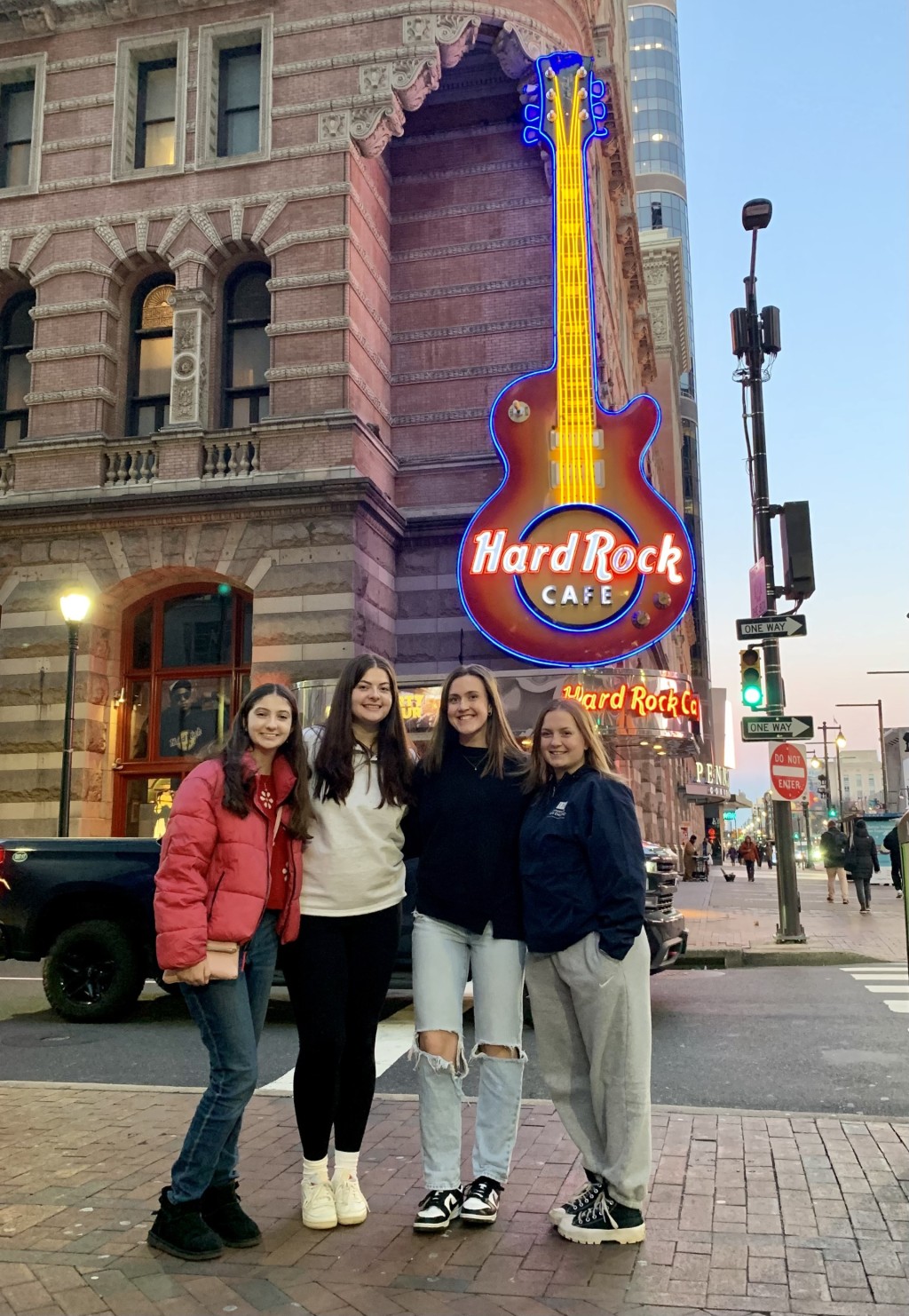 Four female students pose in front of Philadelphia's Hard Rock Cafe