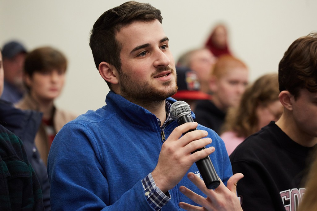A student asks a question from the crowd of a President's Forum