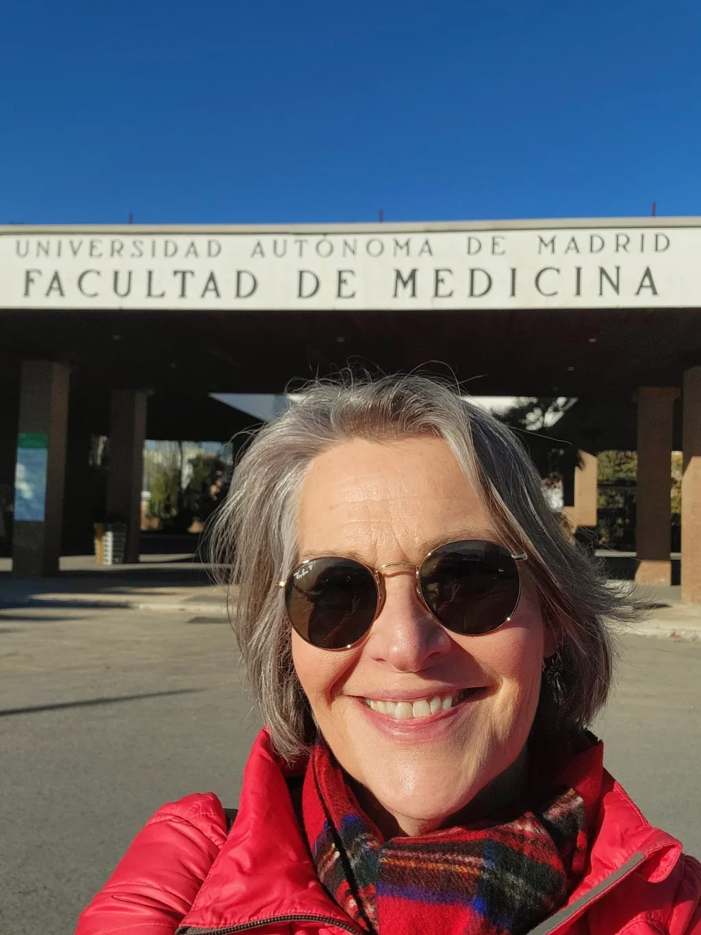 A woman poses in front of a Spanish university building