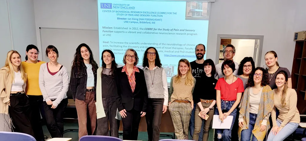 A group of people pose in front of a research presentation