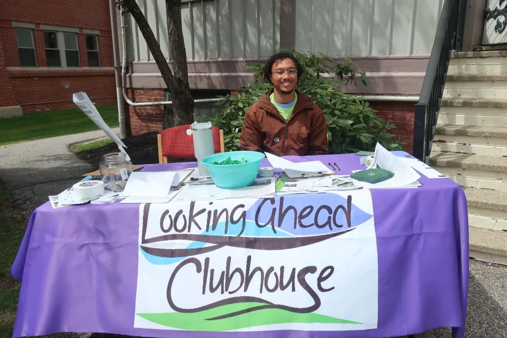 A UNE student sits at an information table