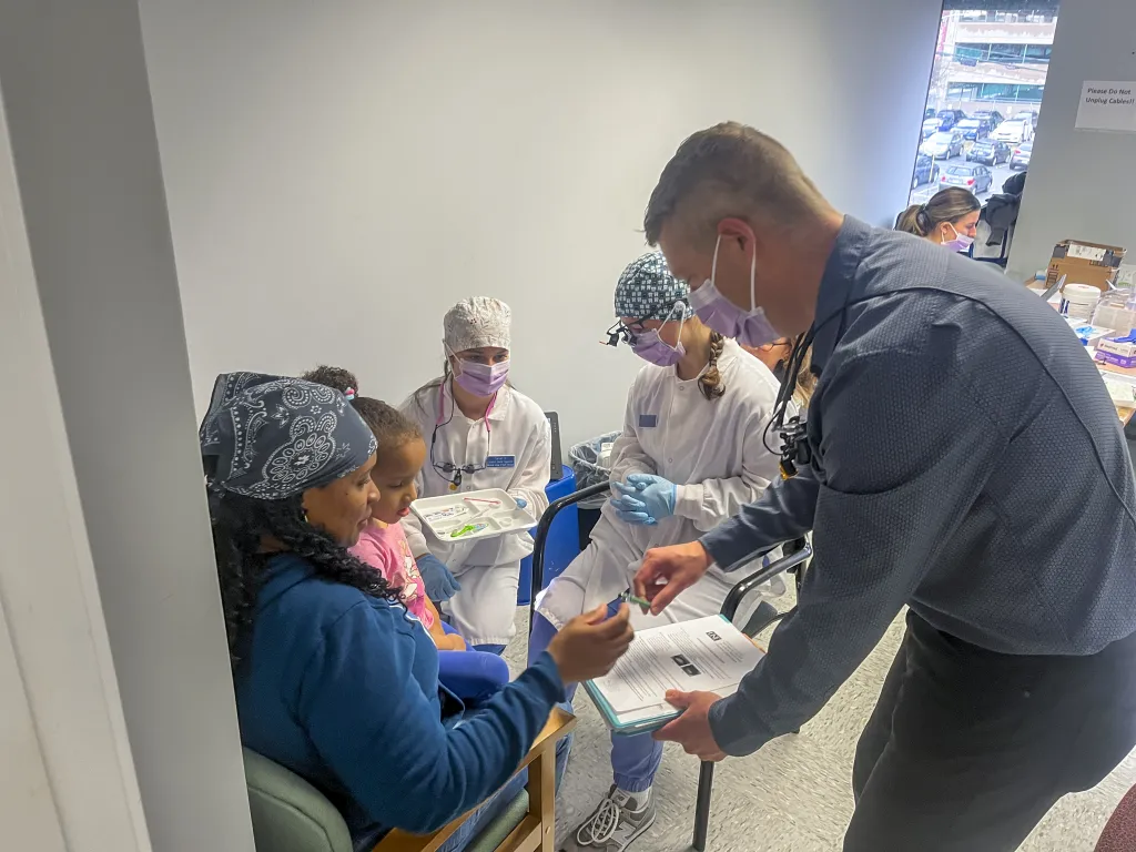 Dental Hygiene students and faculty interact with a family at a local WIC center