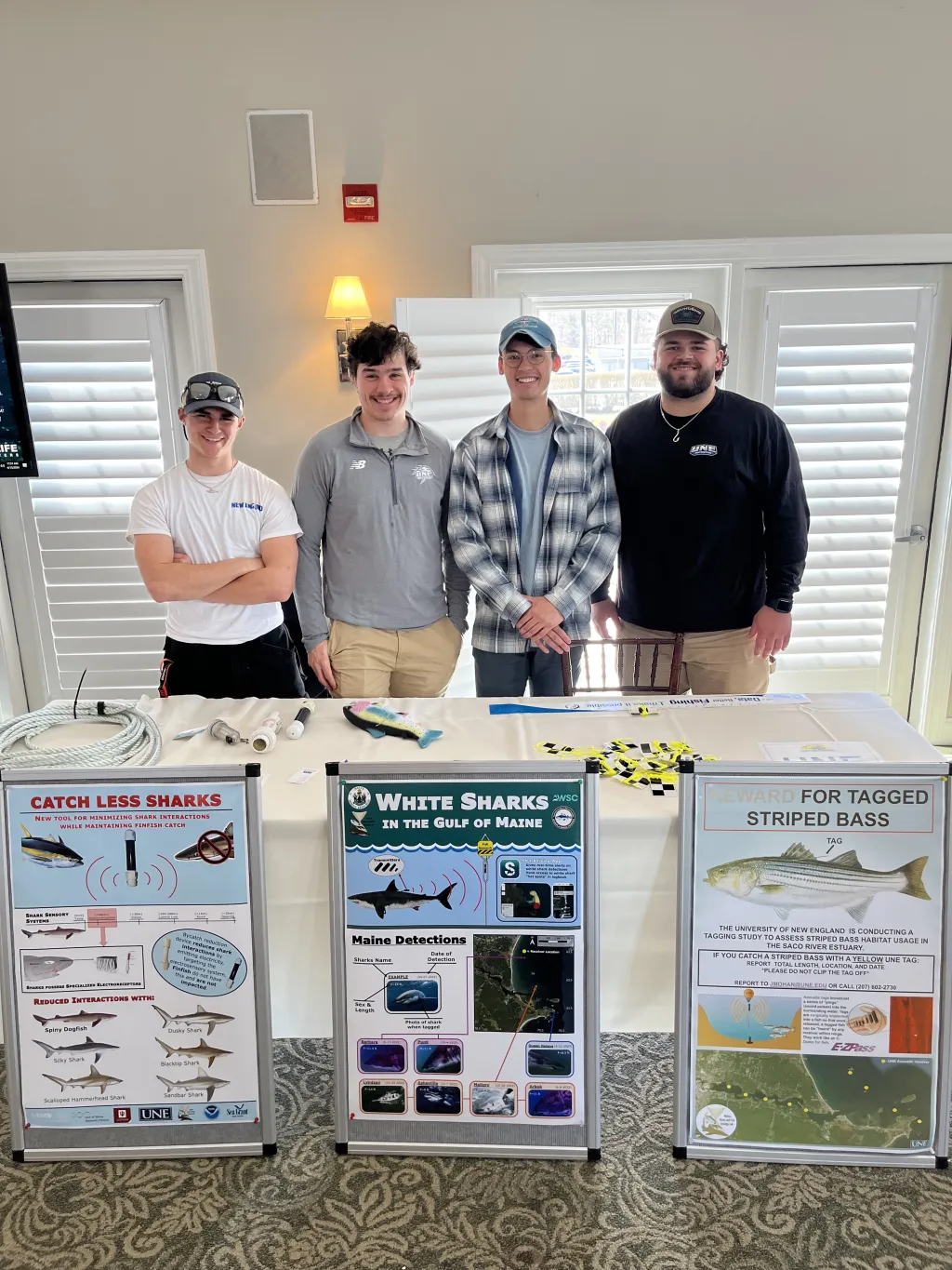 Four UNE students pose with their research posters