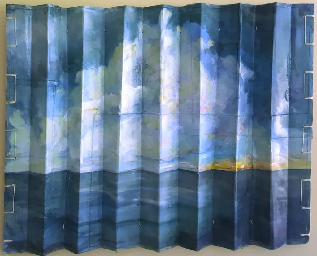 A seascape painted onto an accordion in a mixed media work