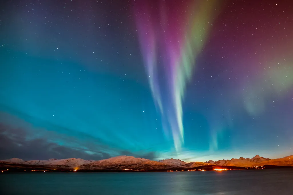 Pink and green northern lights in a night sky