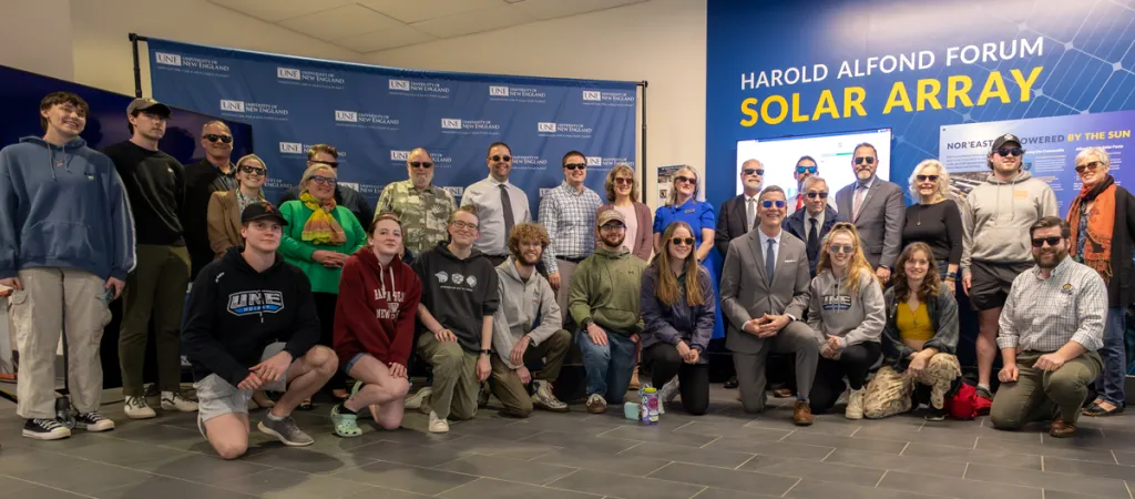 President James Herbert poses with a group of faculty, staff, and students in sunglasses to celebrate new Solar Array at U N E