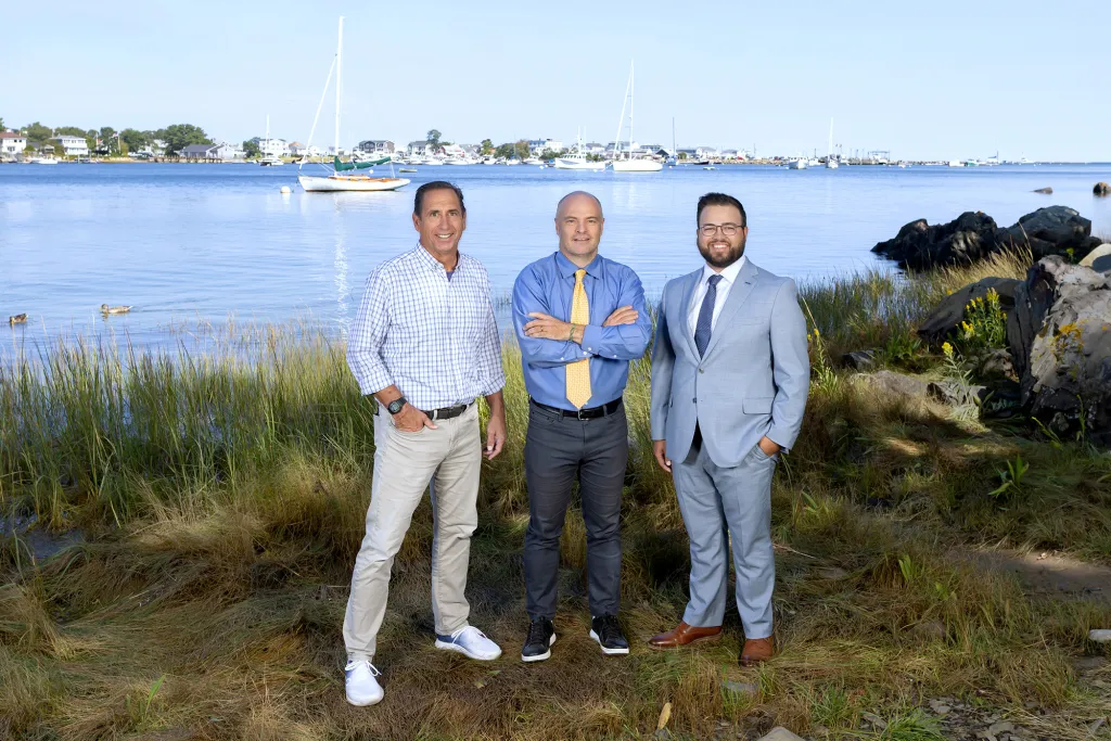 Left to right: Tom Morgan Director, Center for Sales Excellence, Norm O’Reilly, Ph.D., Dean, College of Business, and Connor Blake, MBA. Manager, Center for Sport and Business Innovation standing in front of the Saco River on UNE Biddeford Campus