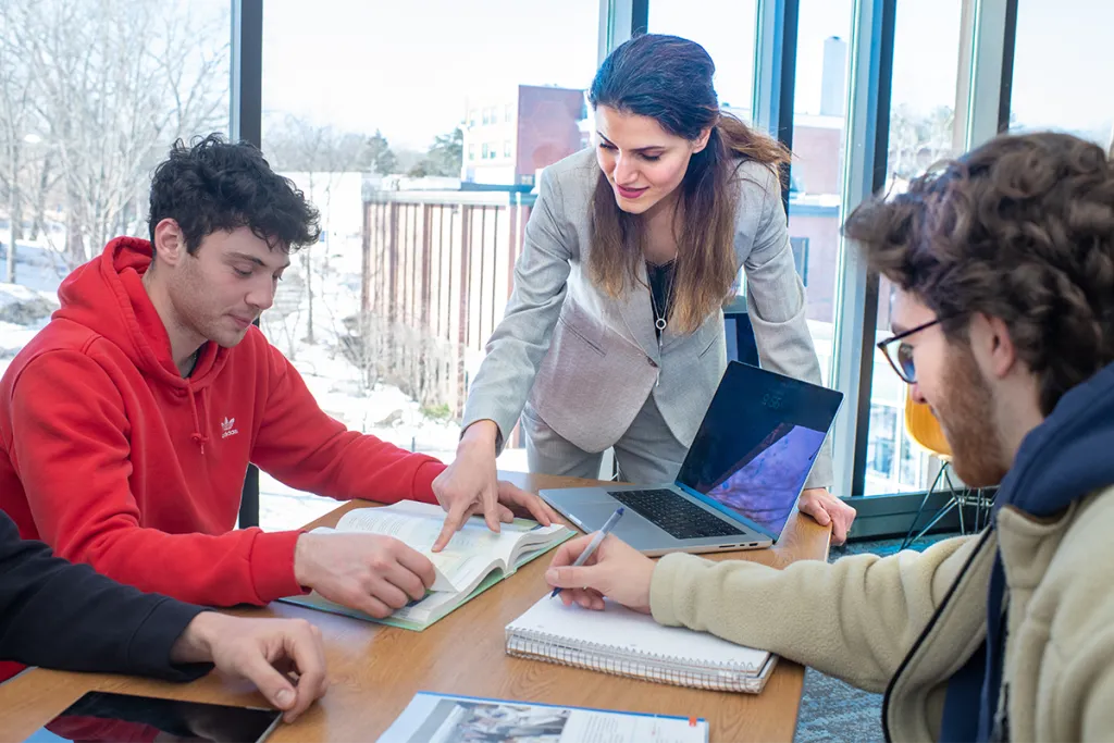 Two C O B students talk with their professor
