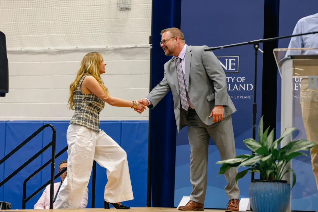 Wes Renfro shakes hand with a student at University Award Ceremony