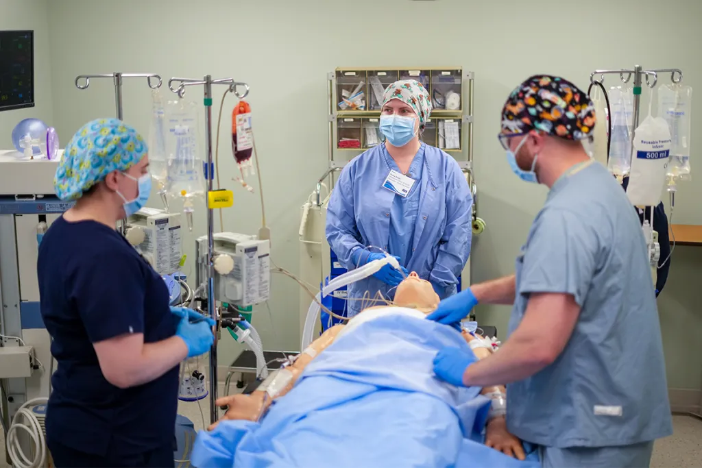Nursing anesthesia students prep a patient simulator for anesthesia in a sim lab operatory room