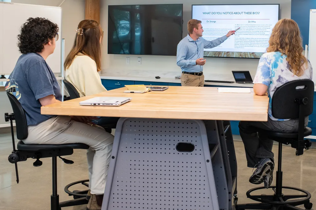 A professor talks to a group of three students
